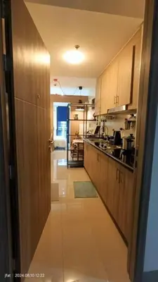 a kitchen with wooden cabinets and a long hallway at Modern Rustic 1-Bed Condo in MoA Complex in Manila