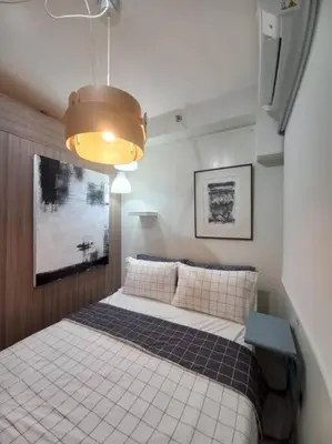 a bedroom with a bed and a light at Modern Rustic 1-Bed Condo in MoA Complex in Manila