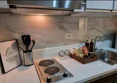 a kitchen counter with a stove and a sink at 1br at Air Makati Ayala near Makati med in Manila