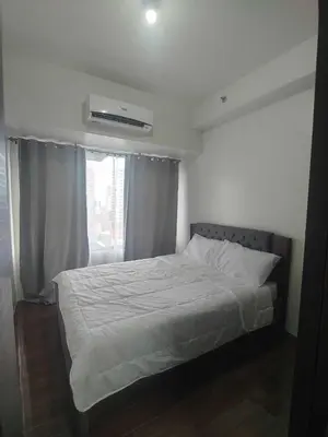a bedroom with a white bed with a window at 1br at Air Makati Ayala near Makati med in Manila