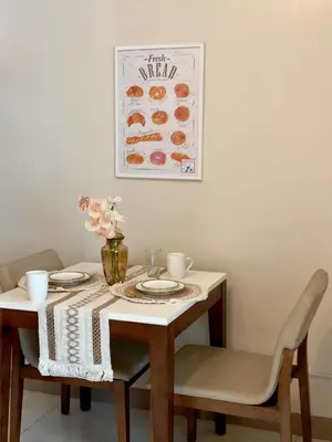 a dining room table with a white table and chairs at Cozy 1BR Condo with Uptown Mall View - BGC Zen Suite in Manila