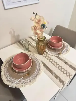 a table with two plates and a vase with flowers at Cozy 1BR Condo with Uptown Mall View - BGC Zen Suite in Manila