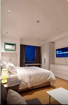 a bedroom with a large bed and a tv at Deluxe Studio good for 3 adults in Novotel Suites Manila with City View in Manila