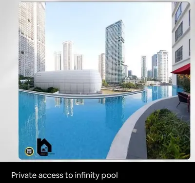 a large swimming pool in a city with buildings at Deluxe Studio good for 3 adults in Novotel Suites Manila with City View in Manila
