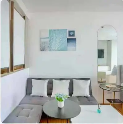 a living room with a couch and a table at Deluxe Studio good for 3 adults in Novotel Suites Manila with City View in Manila