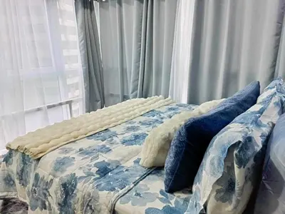 a bed with blue pillows on it in a bedroom at Modern Chic 2BR with Panoramic Golf View in BGC in Manila