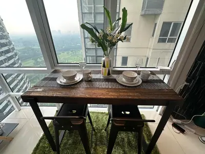 a table in a room with a large window at Modern Chic 2BR with Panoramic Golf View in BGC in Manila