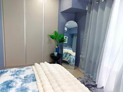 a bedroom with a bed and a mirror at Modern Chic 2BR with Panoramic Golf View in BGC in Manila