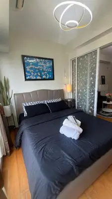 a bedroom with a large bed with a blue blanket at Cloud Nine Escape in Manila