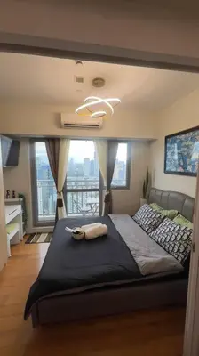 a bedroom with a large bed with a large window at Cloud Nine Escape in Manila