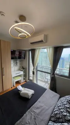 a bedroom with a bed and a large window at Cloud Nine Escape in Manila