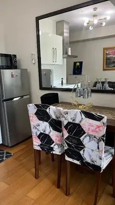 a kitchen with a table and a refrigerator at Cloud Nine Escape in Manila