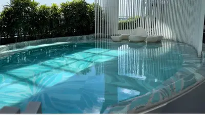 a swimming pool with two white chairs sitting on top of it at Cloud Nine Escape in Manila