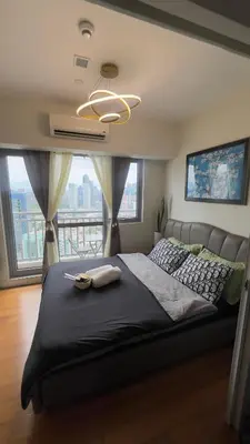 a bedroom with a large bed with a large window at Cloud Nine Escape in Manila