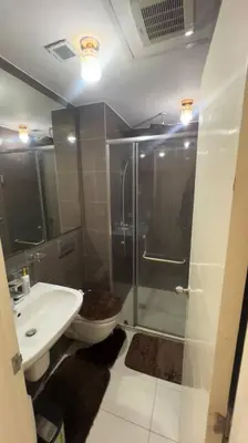 a bathroom with a shower and a toilet and a sink at Cloud Nine Escape in Manila