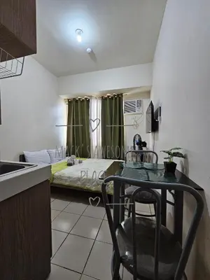 a kitchen with a table and a bed in a room at Macks Awesome 12 Place Fast Wifi Netflix in Manila