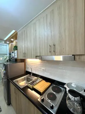 a kitchen with a sink and a stove top oven at Katkat Shore 2 Staycation in Manila