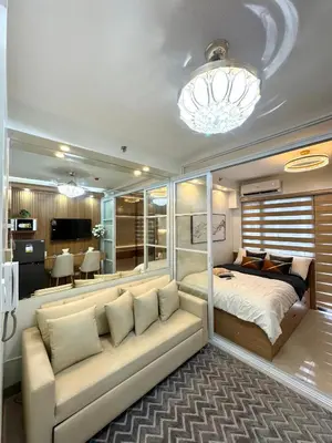 a bedroom with a couch and a bed in a room at Katkat Shore 2 Staycation in Manila