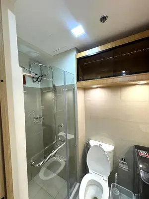 a bathroom with a toilet and a glass shower at Katkat Shore 2 Staycation in Manila