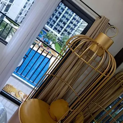 a chair with a lamp in front of a window at Shore 2 Residences MOA DMBV in Manila