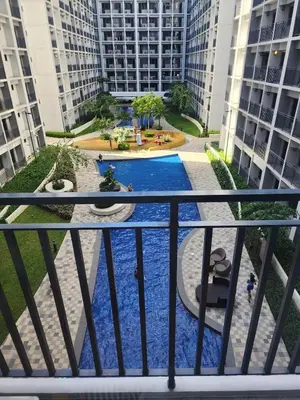 a view of a pool from a balcony with buildings at Shore 2 Residences MOA DMBV in Manila