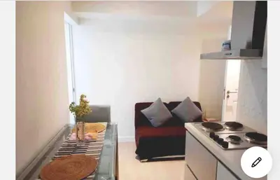 a small living room with a couch and a stove at 2BR Cozy Condo at Azure Urban Resort Residences by Gigi in Manila