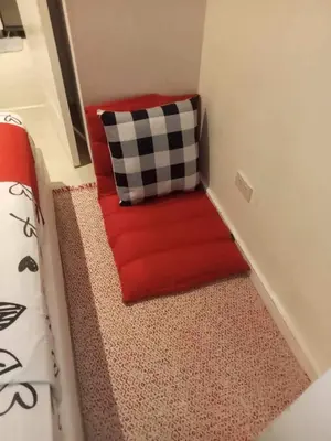 a staircase with a red couch and a checkered pillow at 2BR Cozy Condo at Azure Urban Resort Residences by Gigi in Manila