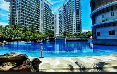 a large pool with blue water in front of tall buildings at 2BR Cozy Condo at Azure Urban Resort Residences by Gigi in Manila