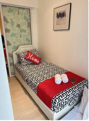 a bedroom with a bed with two pillows on it at 2BR Cozy Condo at Azure Urban Resort Residences by Gigi in Manila