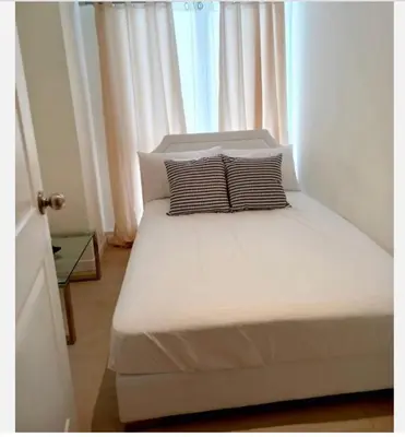 a bed with two pillows in a room with a window at 2BR Cozy Condo at Azure Urban Resort Residences by Gigi in Manila