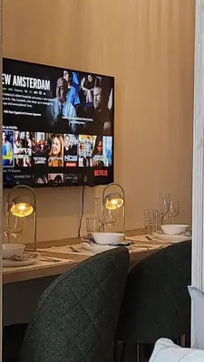 a table with two chairs and a television on the wall at The New Villa at Shore 2 Residences in Manila