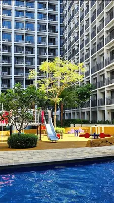 a playground with a slide in front of a large building at The New Villa at Shore 2 Residences in Manila