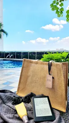 a tablet computer sitting on a blanket next to a pool at The New Villa at Shore 2 Residences in Manila