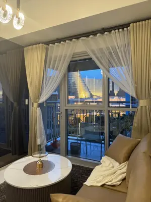 a living room with a couch and a large window at Stylish 1BR Near Airport Facing the Bay - 9d in Manila