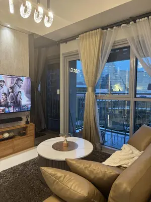 a living room with a couch and a tv at Stylish 1BR Near Airport Facing the Bay - 9d in Manila