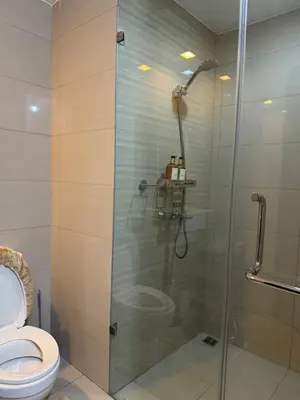 a shower stall in a bathroom with a toilet at Stylish 1BR Near Airport Facing the Bay - 9d in Manila