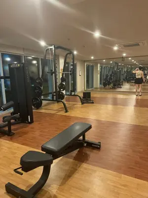 a gym with several treadmills and a woman in the background at Stylish 1BR Near Airport Facing the Bay - 9d in Manila