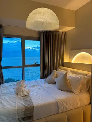 a bedroom with a large bed with a large window at Panoramic Seaview 2BR Near Airport Facing the Bay - 7g in Manila