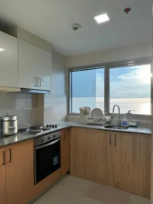a kitchen with a sink and a stove and a window at Panoramic Seaview 2BR Near Airport Facing the Bay - 7g in Manila