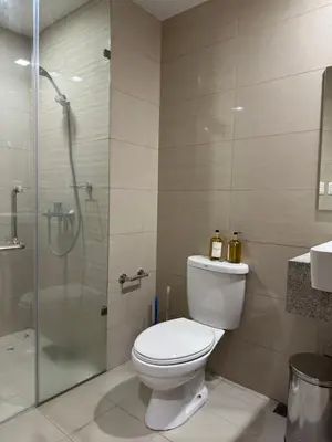 a bathroom with a toilet and a glass shower at Panoramic Seaview 2BR Near Airport Facing the Bay - 7g in Manila