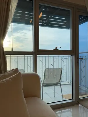 a living room with a window and a chair at Panoramic Seaview 2BR Near Airport Facing the Bay - 7g in Manila
