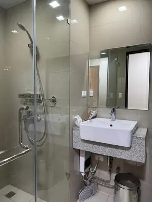 a bathroom with a sink and a glass shower at Panoramic Seaview 2BR Near Airport Facing the Bay - 7g in Manila