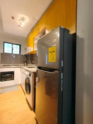 a kitchen with a refrigerator and a washer and dryer at Fully-furnished 2BR Condo in Pasig, Cainta in Cainta