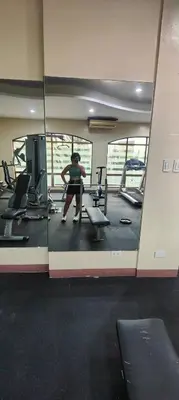 a woman is sitting in a gym in a mirror at Fully-furnished 2BR Condo in Pasig, Cainta in Cainta