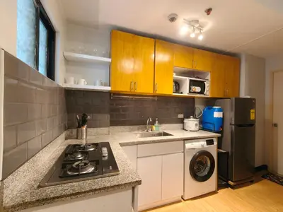 a kitchen with a stove and a sink and a refrigerator at Fully-furnished 2BR Condo in Pasig, Cainta in Cainta