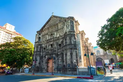 an old stone building on the corner of a street at Lancaster Hotel Manila in Manila