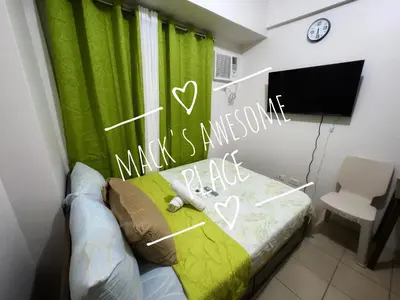 a bedroom with a bed with a green curtain at Macks Awesome 07 Fast Wifi Premium Netflix in Manila