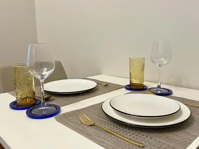 a table with plates and wine glasses on it at Affordable One Bedroom at One Uptown, BGC Manila in Manila