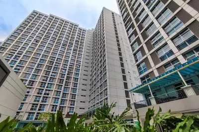 two tall buildings with trees in front of them at Japanese Stylish Condo in Makati in Manila