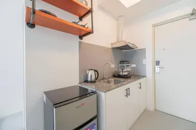 a small kitchen with white cabinets and a sink at Japanese Stylish Condo in Makati in Manila